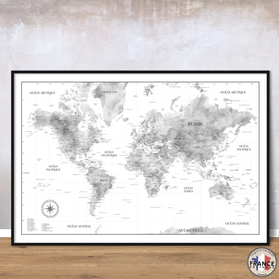 Carte du monde noir et blanc "Gabriel" aux nuances aquarelle posée contre un mur sur un sol bois