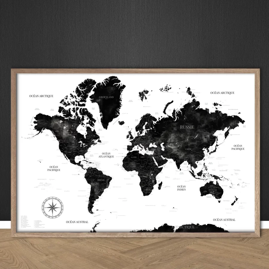 Carte du monde "Inès" aux nuances aquarelle noires et blanches posée contre un mur sur un sol bois