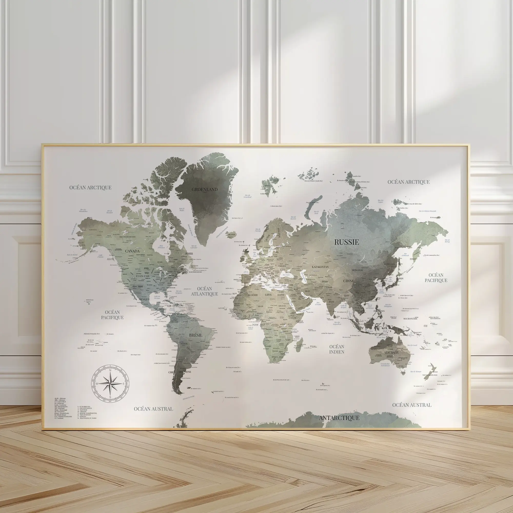 Carte du monde aux tonalités neutres encadrée et posée contre un mur